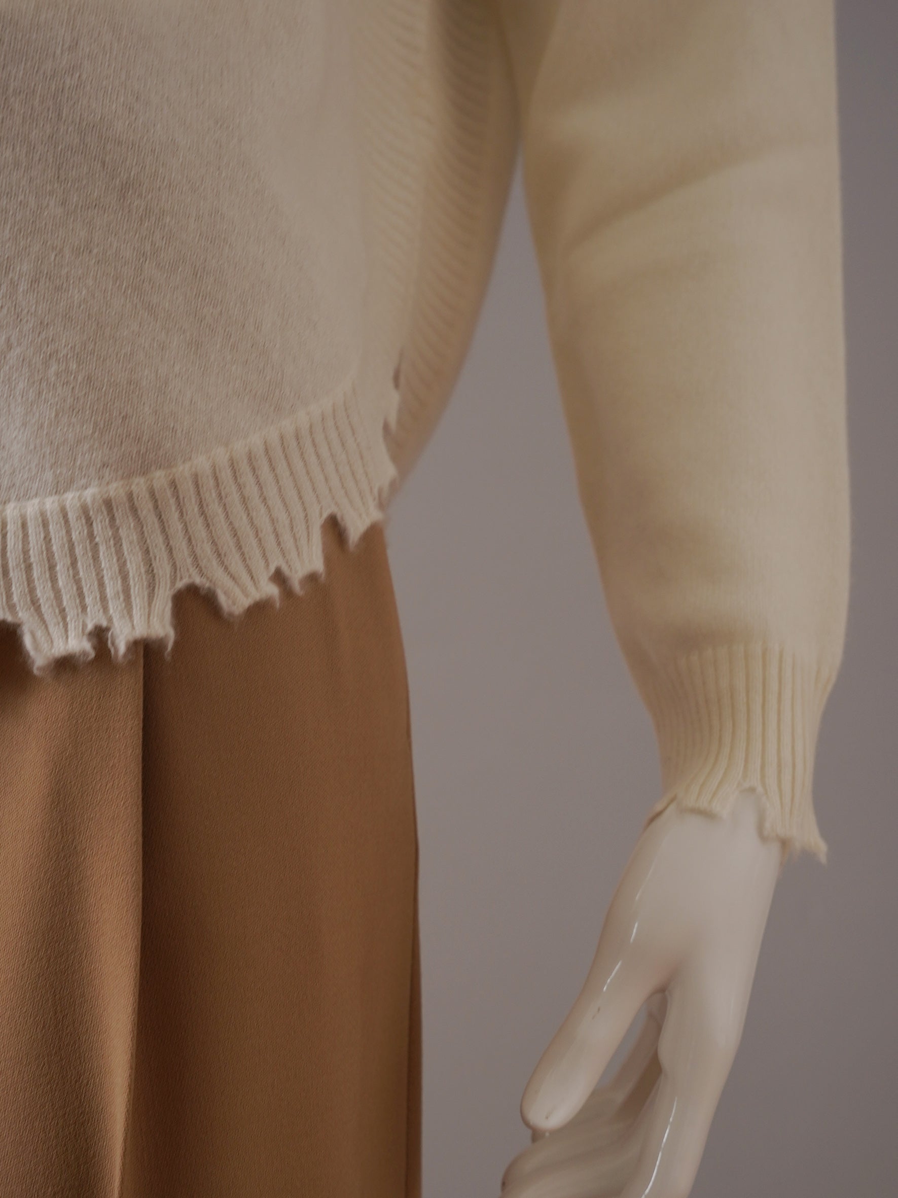 Cream-colored cashmere sweater with destroyed hem